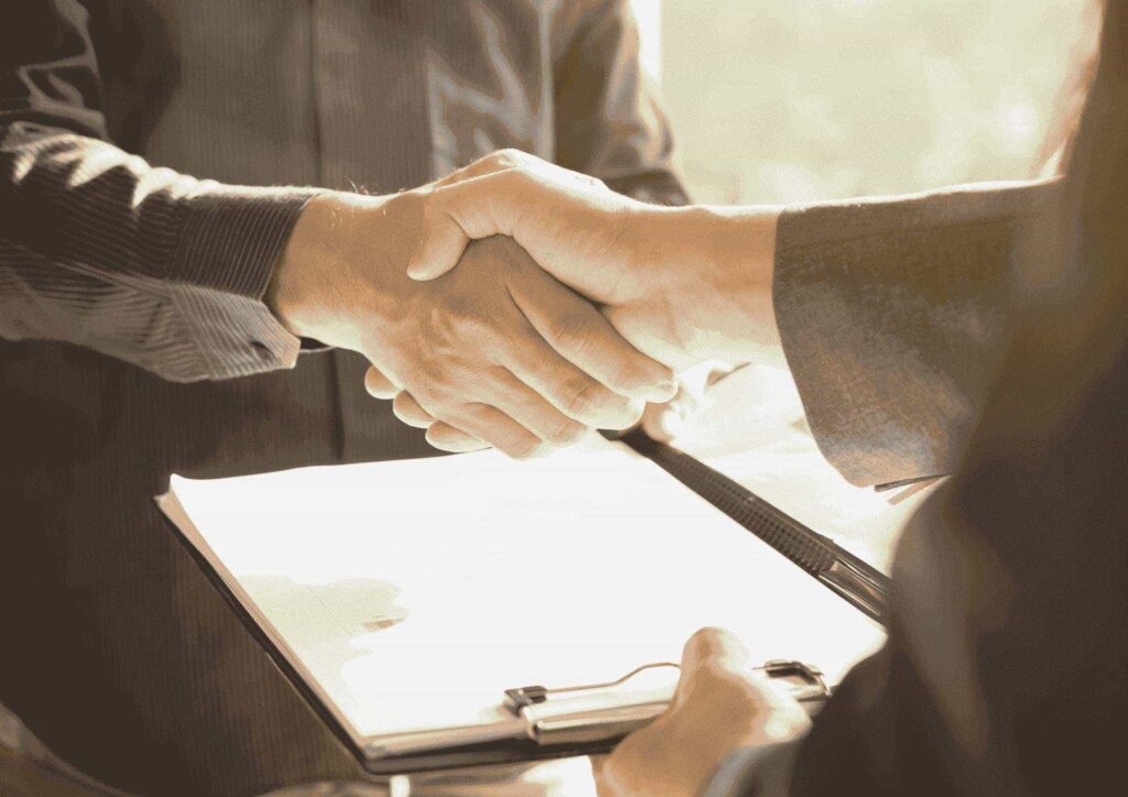 duas pessoas apertando a mão e fechando um contrato de manutenção em gerador de energia